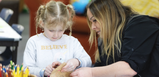 Early childhood educator with a young girl in an daycare setting