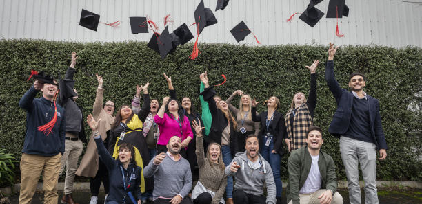 Metricon graduates throwing hats in the air 